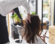 Close up of hairdresser using hair dryer